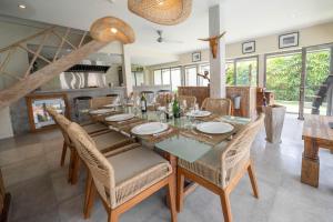 スミニャックにあるVilla Amana Seminyakの長いテーブルと椅子のあるダイニングルーム