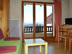 a room with a bed and a table and a balcony at Appartement calme centre station avec parking - FR-1-593-41 in Les Angles