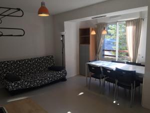un soggiorno con un divano, un tavolo e delle sedie di Charmant appartement au pied des pistes, pour 6 personnes avec parking et casier à skis - FR-1-602-61 ad Arette