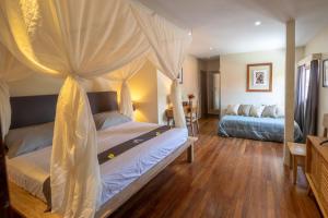 a bedroom with two beds with a canopy at Villa Amana Seminyak in Seminyak +53 photos
