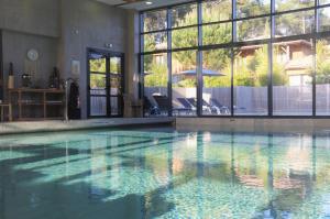 a large swimming pool with a clear blue water at Domaine du Ferret Restaurant & Spa in Cap-Ferret
