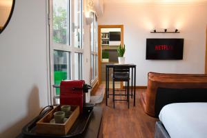 um quarto com uma cama, uma mesa e uma janela em The Attic Centrale - Netflix em Milão