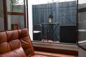uma cadeira de couro sentada em frente a uma janela em The Attic Centrale - Netflix em Milão