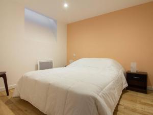 Schlafzimmer mit einem weißen Bett und Holzboden in der Unterkunft Appartement Cauterets, 4 pièces, 9 personnes - FR-1-401-181 in Cauterets