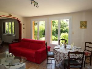 ein Wohnzimmer mit einem roten Sofa und einem Tisch in der Unterkunft Appartement Bagnères-de-Luchon, 3 pièces, 6 personnes - FR-1-313-177 in Luchon