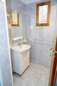 La salle de bains blanche est pourvue d'un lavabo et d'un miroir. dans l'établissement B&B La Strea, à Porto Cesareo