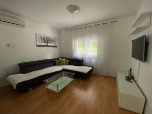 een woonkamer met een bank en een tv bij Holiday home Povile in Novi Vinodolski