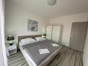 een slaapkamer met een groot bed en een spiegel bij Holiday home Povile in Novi Vinodolski