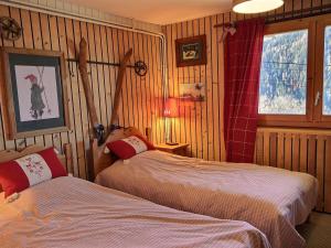 two beds in a room with wood paneled walls at Chalet 10 pers au calme à 1 km de la station, 5 pièces avec WiFi et parking - FR-1-411-683 in Landry