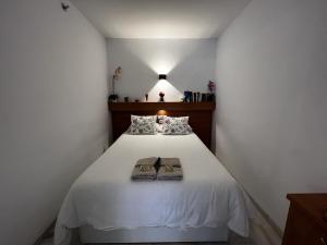 een slaapkamer met een wit bed en 2 handdoeken bij 797 Holiday Rentals- Apartamento en Hotel Sunset Beach frente al mar in Benalmádena