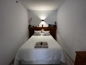 sypialnia z białym łóżkiem i 2 ręcznikami w obiekcie 797 Holiday Rentals- Apartamento en Sunset frente al mar w mieście Benalmádena +34 zdjęcia