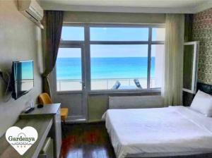 a bedroom with a large window with a view of the ocean at Inebolu Gardenya Hotel in Inebolu
