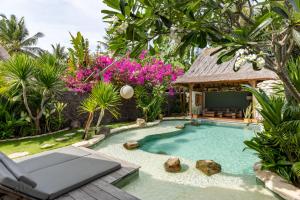 a swimming pool in a garden with a gazebo at Kuno Villas in Gili Trawangan