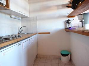 una pequeña cocina con armarios blancos y fregadero en Appartement Peisey-Vallandry, 2 pièces, 7 personnes - FR-1-411-649, en Landry
