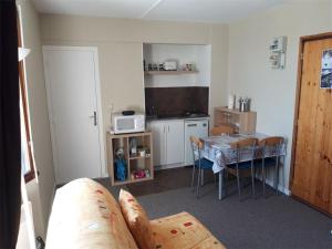 Cette chambre comprend une cuisine avec une table et une salle à manger. dans l'établissement Studio cosy avec accès direct aux pistes à Arette - 4 personnes, casier à skis, parking gratuit - FR-1-602-62, à Arette