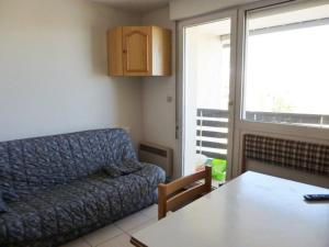 sala de estar con sofá azul y mesa en Studio Arette, 1 pièce, 4 personnes - FR-1-602-42 en Arette