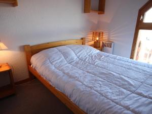 Un dormitorio con una cama con una manta azul. en Appartement Peisey-Vallandry, 2 pièces, 7 personnes - FR-1-411-649, en Landry
