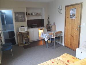Cette chambre comprend une cuisine avec une table et un lit. dans l'établissement Studio cosy avec accès direct aux pistes à Arette - 4 personnes, casier à skis, parking gratuit - FR-1-602-62, à Arette
