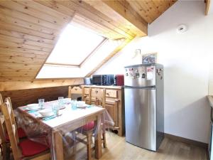 a kitchen with a table and a stainless steel refrigerator at Appartement Briançon, 1 pièce, 4 personnes - FR-1-330C-116 in Briançon