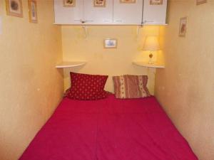 Piccola camera con letto rosa e 2 cuscini. di Appartement Les Orres, 1 pièce, 6 personnes - FR-1-322-403 a Les Orres