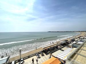 a view of a beach with people and the ocean at Appartement spacieux 1er étage avec balcon, vue mer, double garage à Saint-Gilles-Croix-de-Vie - FR-1-224-775 in Saint-Gilles-Croix-de-Vie