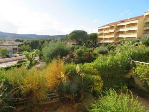 um jardim em frente a um edifício com plantas em Appartement Bormes-les-Mimosas, 2 pièces, 4 personnes - FR-1-610-16 em Bormes-les-Mimosas