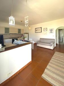 uma grande sala de estar com um balcão e um sofá em Casa Morlè em Marina di Campo