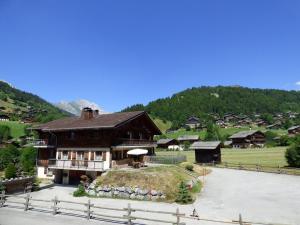 Una casa grande con un montón de hierba. en Appartement Le Grand-Bornand, 6 pièces, 10 personnes - FR-1-458-135 en Le Grand-Bornand