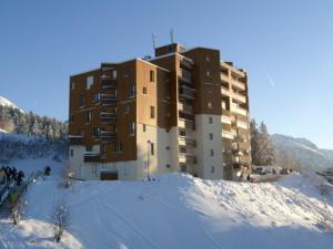 un edificio en la cima de una montaña cubierta de nieve en Appartement Les Adrets-Prapoutel, 1 pièce, 3 personnes - FR-1-557-80, en Les Adrets