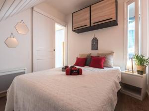 a bedroom with a bed with a red suitcase on it at Duplex rénové pour 4 à Saint-Lary près des pistes et commodités - FR-1-296-300 in Saint-Lary-Soulan