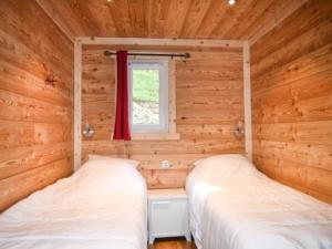 two beds in a log cabin with a window at Appartement Montgenèvre, 3 pièces, 6 personnes - FR-1-266-164 in Montgenèvre