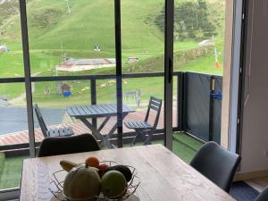 a table with a bowl of fruit on it in front of a window at Studio cabine 5 pers - Pied des pistes - Parking couvert - Balcon - FR-1-404-236 in La Mongie
