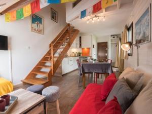a living room with a red couch and a staircase at Duplex rénové pour 4 à Saint-Lary près des pistes et commodités - FR-1-296-300 in Saint-Lary-Soulan