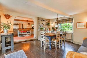 Finest Retreats - Islip Mill House - Beautiful Riverside Home في Islip: مطبخ مفتوح وغرفة طعام مع طاولة وكراسي