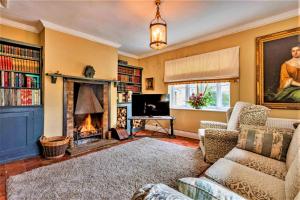 a living room with a fireplace and a tv at Finest Retreats - Islip Mill House - Beautiful Riverside Home in Islip