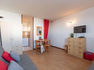 ein Wohnzimmer mit einem Sofa und eine Küche mit einem Tisch in der Unterkunft Studio Saint-Lary-Soulan, 1 pièce, 4 personnes - FR-1-296-311 in Saint-Lary-Soulan