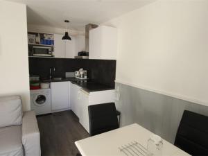 uma cozinha e uma sala de estar com uma mesa em Appartement Bagnères-de-Luchon, 2 pièces, 4 personnes - FR-1-313-159 em Luchon