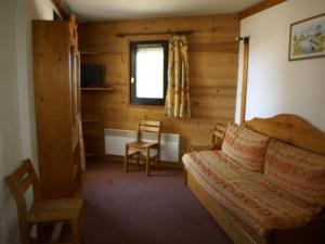 1 dormitorio con 1 cama, 1 silla y 1 ventana en Appartement Les Adrets-Prapoutel, 2 pièces, 4 personnes - FR-1-557-8 en Les Adrets