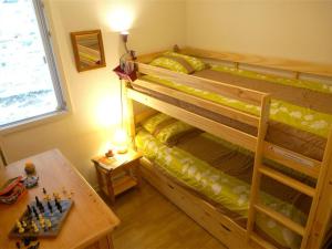 um quarto com um beliche com um tabuleiro de xadrez sobre uma mesa em Appartement Bagnères-de-Luchon, 3 pièces, 4 personnes - FR-1-313-186 em Luchon