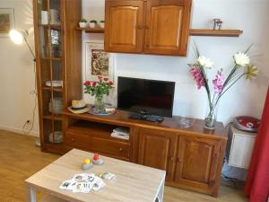 uma sala de estar com uma televisão e uma mesa em Appartement Bagnères-de-Luchon, 3 pièces, 4 personnes - FR-1-313-186 em Luchon