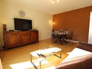 een woonkamer met een flatscreen-tv en een tafel bij Appartement Bagnères-de-Luchon, 2 pièces, 4 personnes - FR-1-313-195 in Luchon