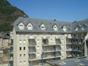 a large apartment building with a gray roof at Appartement 2 pièces cabine avec balcon, parking, animaux admis, Wi-Fi - FR-1-313-195 in Luchon