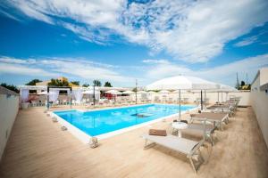 einen Pool mit Stühlen und Sonnenschirmen auf einem Gebäude in der Unterkunft Bono Vacanze Villa San Marco Luxury Holidays Homes & Hotel in Sciacca