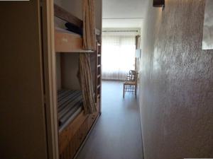 - un couloir avec une chambre dotée de lits superposés et d'une fenêtre dans l'établissement Appartement Arette, 2 pièces, 6 personnes - FR-1-602-28, à Arette