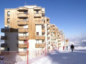 un edificio en la nieve con gente caminando delante de él en Appartement Les Adrets-Prapoutel, 2 pièces, 4 personnes - FR-1-557-8 en Les Adrets