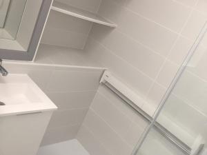 baño blanco con ducha y lavamanos en Studio Arette, 1 pièce, 5 personnes - FR-1-602-43, en Arette