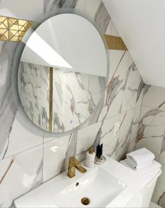 bagno con lavandino e specchio di APART KARKONOSZE - Klimatyzowany Apartament Charlotte Karpacz na deptaku z parkingiem w cenie a Karpacz