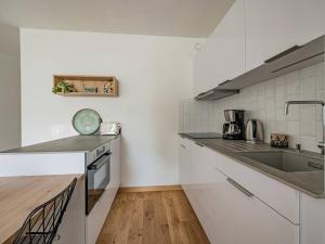 cocina blanca con fregadero y encimera en Appartement Bénodet, 2 pièces, 4 personnes - FR-1-481-80, en Bénodet