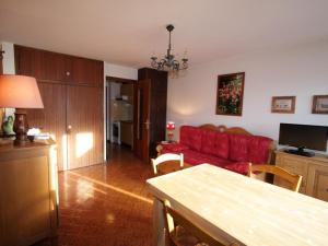 a living room with a red couch and a table at Studio Le Grand-Bornand, 1 pièce, 4 personnes - FR-1-458-89 in Le Grand-Bornand