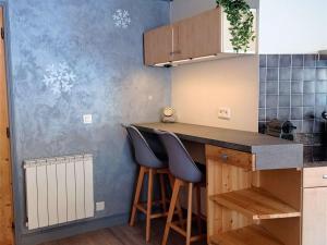 a kitchen with two stools at a kitchen counter at Bel appartement 6/8 pers avec balcon, au cœur de Val Thorens - FR-1-545-21 in Val Thorens